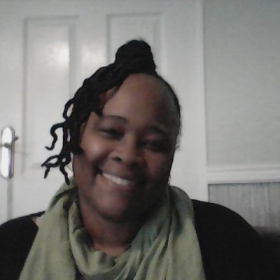 Carol Allen, smiling, wearing a sage green scarf